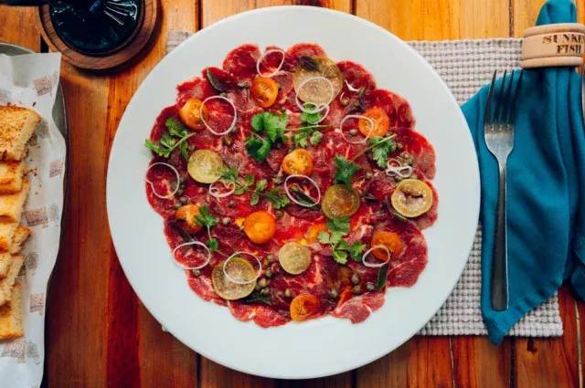 BEEF CARPACCIO: Thin slices of beef tenderloin perfectly marinated with balsamic vinaigrette and topped with red onion, capers, dehydrated tomatoes, and Parmesan Reggiano cheese. Served with freshly baked in-house focaccia. 

#honduras #roatan #sandybay #sunkenfish #tranquilseas #beachrestaurant #bestfoodroatan #bestfood #caribbean #thebestrestaurant